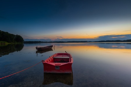 Beautiful lake sunset with fisherman boats.  の写真素材
