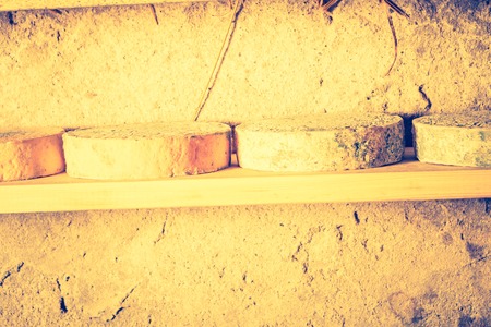 Vintage photo of cheese maturing in basement. French goat cheese. Studio shoot with mystic light effect.の写真素材
