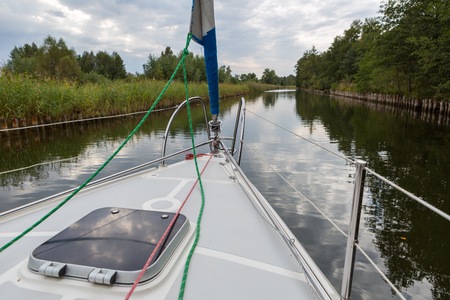 Front part of yacht swimming on lake. Beutiful Mazury lake photographed from yacht.の写真素材