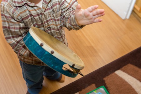 Small child playing on drum. Little caucasian boy and drum. Hands close upの写真素材