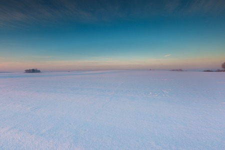 Beautiful cold morning on snowy winter countryside. Polish countryside at snowy winter.の写真素材