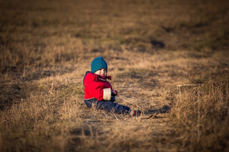 Young happy boy playing outdoor in beautiful rural landscape in golden light at spring. Happy childhood spent in the countryside.の写真素材