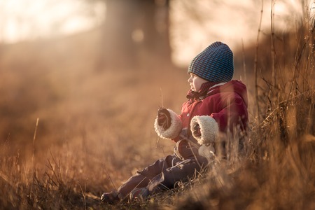 Young happy boy playing outdoor in beautiful rural landscape in golden light at spring. Happy childhood spent in the countryside.の写真素材