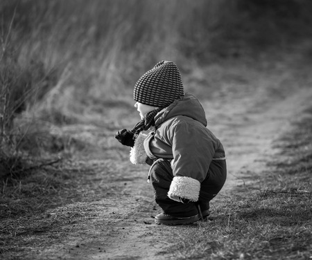 Young happy boy playing outdoor in beautiful rural landscape in golden light at spring. Happy childhood spent in the countryside.の写真素材