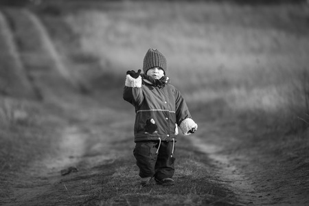 Young happy boy playing outdoor in beautiful rural landscape in golden light at spring. Happy childhood spent in the countryside.の写真素材
