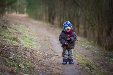 Little bad boy screaming outdoor near forest. Angry child with serious face.の写真素材