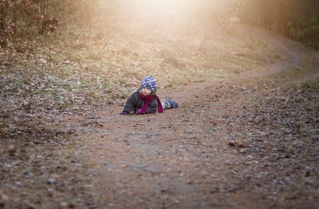 Little boy playing outdoor near forest. Beautiful child photo with golden light.の写真素材