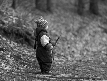 Little boy playing in forest at early spring. Happy childhood spent in ntaure. Caucasian child playing outdoorの写真素材