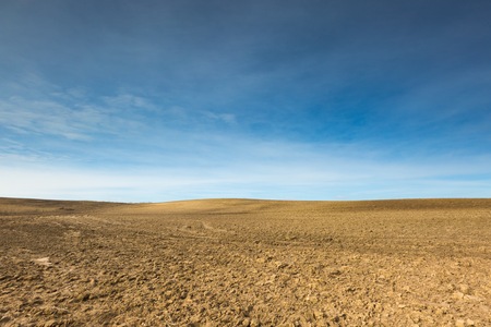 Early springtime plowed field landscape. Polish field at sunny spring day under blue skyの写真素材
