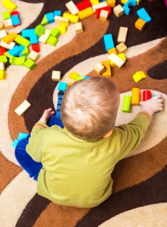 Small child playing with wooden blocks. Caucasian boy building with blocksの写真素材