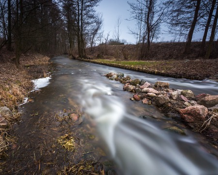 Long exposure photo of dam on river. Landscape with building.の写真素材