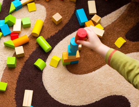 Small child playing with wooden blocks. Caucasian boy building with blocksの写真素材