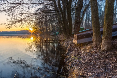 Sunrise over lake at end of winter. Frosty morning with sunrise over lake.の写真素材