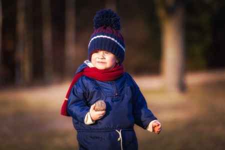 Caucasian boy playing outdoor. Portrait of happy boy playing in springtime landscape.