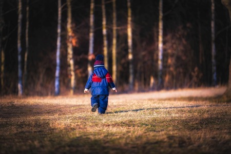 Caucasian boy playing outdoor. Portrait of happy boy playing in springtime landscape.の写真素材