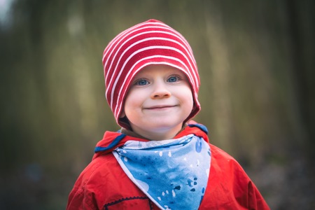 Portrait of small happy boy playing in outdoor. Smiling face.