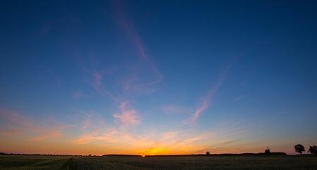 Beautiful after sunset sky over fields in Poland. Natural landscape of countryside at twilightの写真素材