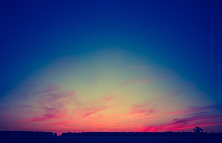 Vintage photo of beautiful sunset over summer field. Natural landscape with vintage mood.の写真素材