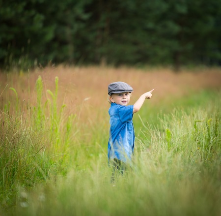 Young boy playing on fields in countryside. Portrait of caucasian happy boy taken in rural polish landscape at evening.の写真素材