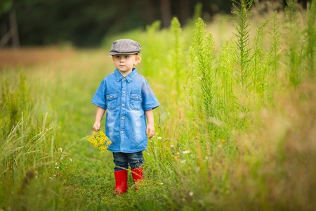 Young boy playing on fields in countryside. Portrait of caucasian happy boy taken in rural polish landscape at evening.の写真素材