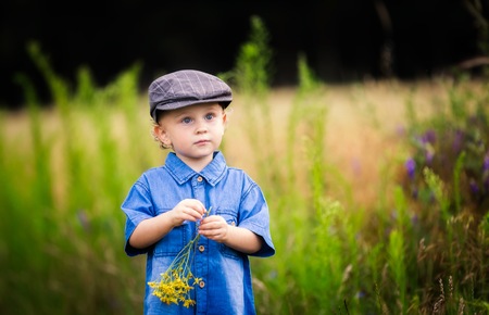 Young boy playing on fields in countryside. Portrait of caucasian happy boy taken in rural polish landscape at evening.の写真素材