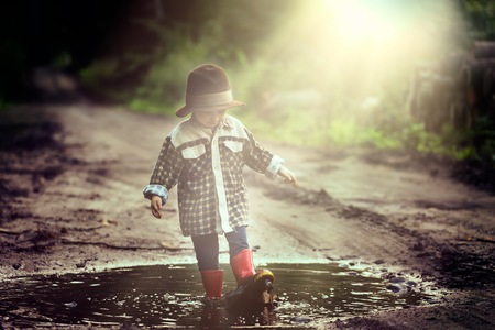 Small boy playing outdoor in summer forest. 3 years old boy in hat playing in nature.の写真素材