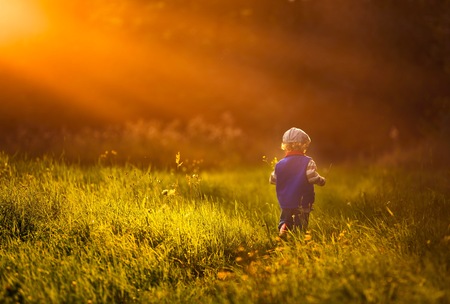 Little caucasian boy playing outdoor in summer. Beautiful baby portrait with magical mood.の写真素材
