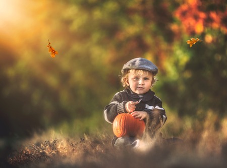 Boy playing outdoor in autumn scenery.の写真素材
