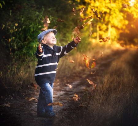 Boy playing outdoor in autumn or spring scenery.の写真素材