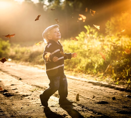 Boy playing outdoor in autumn scenery.の写真素材