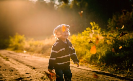 Happy little boy playing outdoor in beautiful autumn scenery.の写真素材