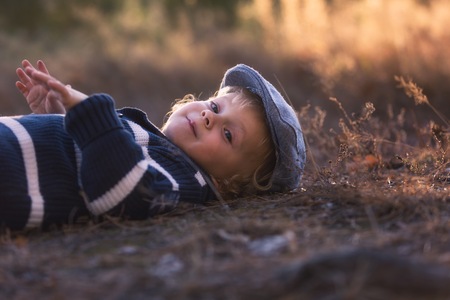 Happy little boy playing outdoor in beautiful autumn scenery.の写真素材