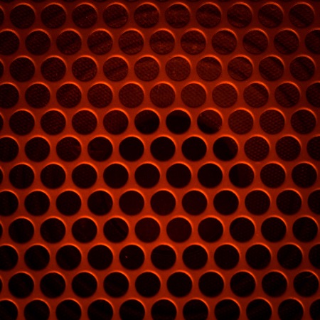 Dark grid background. Close up of aluminum speaker. Texture with holes.の写真素材