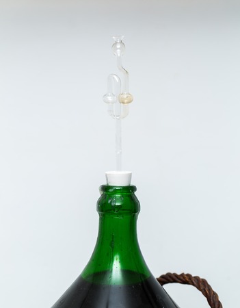 Wine making in home. Demijohn with glass fermentation lock.の写真素材