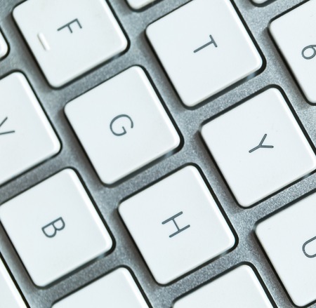 Close up of white wireless aluminum keyboard photographed with shallow depth of field.の写真素材