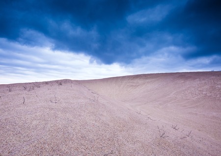 Sand dunes under cloudy sky at evening.の写真素材