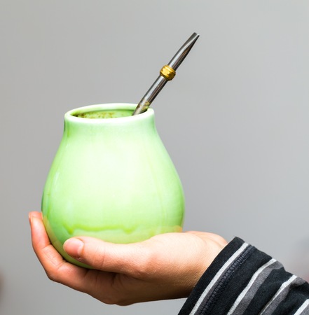 Unrecognizable woman drinking herbal mate from ceramic cup.の写真素材