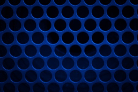 Dark grid background. Close up of aluminum speaker. Texture with holes.の写真素材