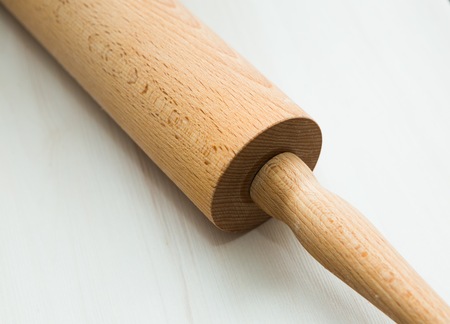 Close up of rolling pin lying on wooden table. Kitchen equipment in close up.の写真素材