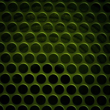 Dark grid background. Close up of aluminum speaker. Texture with holes.の写真素材