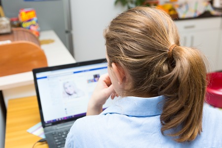 Woman sitting next to laptop screen. Caucasian woman and computer