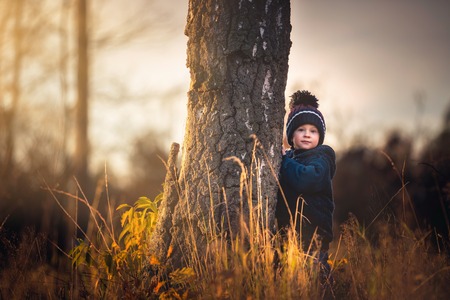 Handsome caucasian boy portrait in autumnal light. Boy playing outdoor.の写真素材