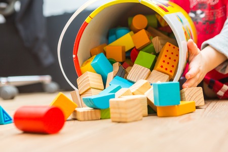 Small boy playing with wooden blocks on floor. Baby toy and child.の写真素材