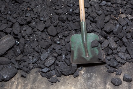 Black coal lying and shovel on a pile in house basement. Fuel material.の写真素材