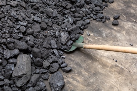Black coal lying and shovel on a pile in house basement. Fuel material.の写真素材