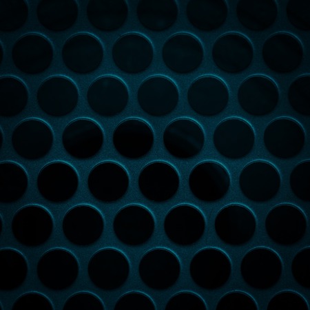 Dark grid background. Close up of aluminum speaker. Texture with holes.の写真素材