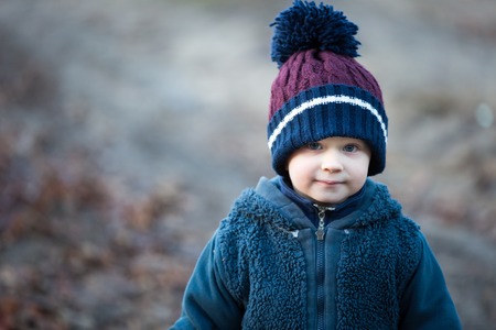 Handsome caucasian boy portrait in autumnal light. Boy playing outdoor.