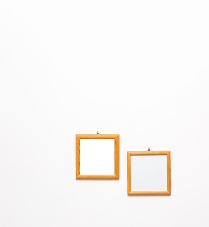 2 old wooden frames of pine wood hanging on white wall background. Wooden frame on white wall.の写真素材