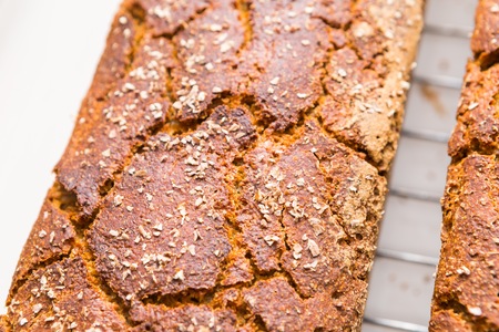 Freshly baked homemade bread lying on metal grille. Natural bread made in kitchen.