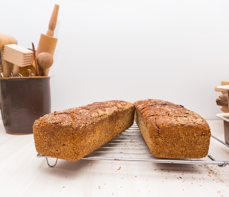 Freshly baked homemade bread lying on metal grille. Natural bread made in kitchen.